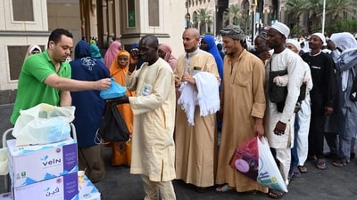 A volunteer hands out food packages offered by the residents of Mecca to pilgrims, as Muslims from around the world arrive to attend the annual Hajj pilgrimage on June 23. The pilgrimage is one of the five pillars of Islam, and all Muslims are required to make the five-day Hajj at least once in their lives if they are physically and financially able to do it, reported AP. ( Sajjad Hussain / AFP) A volunteer hands out food packages offered by the residents of Mecca to pilgrims, as Muslims from around the world arrive to attend the annual Hajj pilgrimage on June 23. The pilgrimage is one of the five pillars of Islam, and all Muslims are required to make the five-day Hajj at least once in their lives if they are physically and financially able to do it, reported AP. ( Sajjad Hussain / AFP)