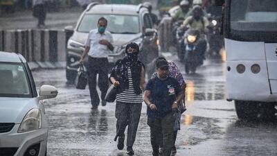 Commuters out in the rain at Delhi’s Pandav Nagar on Tuesday. (Raj K Raj/HT Photo)