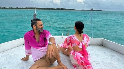 In a photo, Ashesh Sajnani looked at Sonnalli Seygall while she looked into the distance. They twinned in pink outfits. While he wore a pink and white shirt with beige shorts, she opted for a high-slit long dress. 