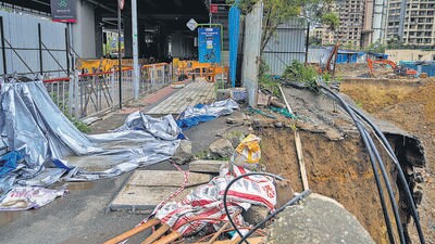 The road has caved in between the under-construction building project and Magathane Metro Station in Mumbai. (Satish Bate/ HT Photo)