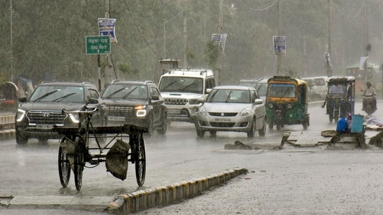 Commuters during rain falling at Birchand Patel Path in Patna, Bihar, Monday, June,26, 2023. (Photo by  Santosh Kumar / Hindustan Times)