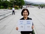 Lee Jung-hee, poses with a whiteboard showing her international age, 58, and Korean age, 59.