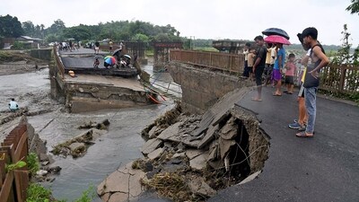 People gather near a damaged bridge that collapsed following a flash flood triggered by heavy rains over the Daranga river at Kumrikata village, in Baksa district of Assam. (ANI) People gather near a damaged bridge that collapsed following a flash flood triggered by heavy rains over the Daranga river at Kumrikata village, in Baksa district of Assam. (ANI)