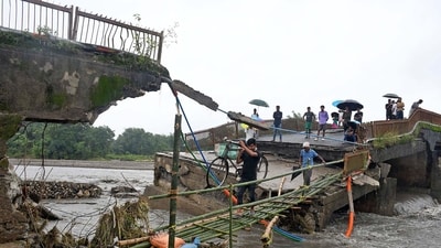 People cross through a makeshift bamboo bridge made over a damaged bridge that collapsed following a flash flood triggered by heavy rains over the Daranga river at Kumrikata village, in Baksa district of Assam. (ANI) People cross through a makeshift bamboo bridge made over a damaged bridge that collapsed following a flash flood triggered by heavy rains over the Daranga river at Kumrikata village, in Baksa district of Assam. (ANI)