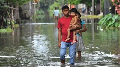 People wade along a street flooded following monsoon rains in Patsala some 103 Km from Guwahati, in Assam on June 23. (AFP) People wade along a street flooded following monsoon rains in Patsala some 103 Km from Guwahati, in Assam on June 23. (AFP)