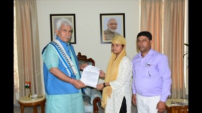 Lieutenant governor Manoj Sinha on Wednesday handed over a job letter to the wife of circus worker Deepu Kumar, who was gunned down by terrorists in Anantnag district last month. (HT photo)