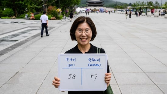 Lee Jung-hee, poses with a whiteboard showing her international age, 58, and Korean age, 59. (AFP)