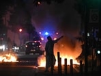 A man walks past a bonfire in a residential area during clashes in Toulouse, southwestern France. (AFP)