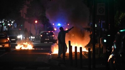 A man walks past a bonfire in a residential area during clashes in Toulouse, southwestern France. (AFP) A man walks past a bonfire in a residential area during clashes in Toulouse, southwestern France. (AFP)