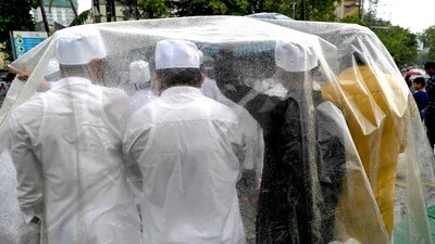 Muslims devotees shelter under a plastic sheet while offering Eid-ul-Adha prayers during a rainy morning in Mumbai on June 29. (AFP) Muslims devotees shelter under a plastic sheet while offering Eid-ul-Adha prayers during a rainy morning in Mumbai on June 29. (AFP)