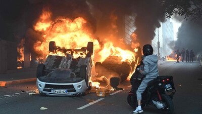 A photo shows cars burning in the street at the end of a commemoration march for a teenage driver shot dead by a policeman, in the Parisian suburb of Nanterre, on June 29, 2023. (AFP)