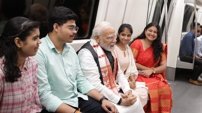 PM Modi interacting with young commuters while travelling via Delhi Metro on Friday. PM Modi interacting with young commuters while travelling via Delhi Metro on Friday.