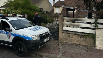 A municipal police officer stands in front of the damaged home of the mayor of l'Hay-les-Roses Vincent Jeanbrun, a suburb of Paris, on Sunday, after rioters rammed a vehicle into the building injuring his wife and one of his children, (AFP) A municipal police officer stands in front of the damaged home of the mayor of l'Hay-les-Roses Vincent Jeanbrun, a suburb of Paris, on Sunday, after rioters rammed a vehicle into the building injuring his wife and one of his children, (AFP)