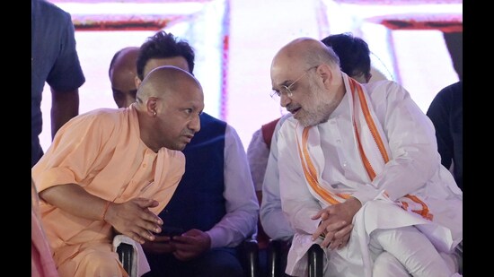 Union home minister Amit Shah and Uttar Pradesh Chief Minister Adityanath sharing a light moment during the Jan Swabhimani Diwas organised in Lucknow, on Sunday. (HT Photo)