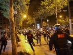 People run followed by police officers during riots in France. 