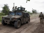 A HMMWV (Humvee) vehicle moves along a road near a the recently retaken village of Novodarivka, amid Russia's attack on Ukraine. 
