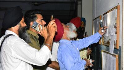 Visitors using their mobile phone flashlights to read the information board at the court complex in Ludhiana. (Manish/HT) Visitors using their mobile phone flashlights to read the information board at the court complex in Ludhiana. (Manish/HT)