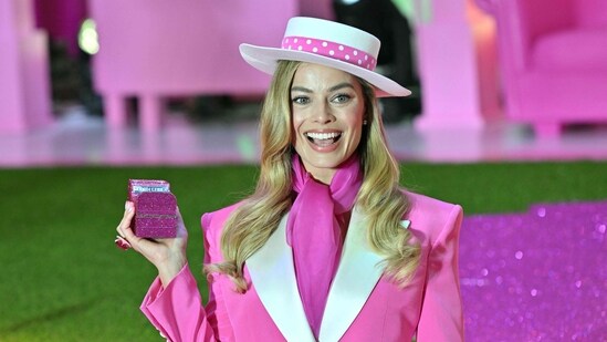 Margot Robbie wore two Versace looks inspired by the 1985 'day to night' Barbie, who was always ready to transition from her work life to her night life at any moment.(AFP)