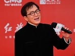 Hong Kong actor Jackie Chan (R) sings as Ethnic Uyghur Chinese actress Gulnezer Bextiyar (L), also known as Gulinazha, looks on as they stand on the red carpet during the opening ceremony of the 13th Beijing International Film Festival (BJIFF) in Beijing, on April 21, 2022. (Photo by Jade GAO / AFP)