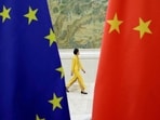 An attendant walks past EU and China flags in Beijing, China. (Reuters/File)
