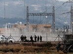 Israeli forces stand near a fence, as an Israeli military operation continues on Jenin refugee camp in the Israeli-occupied West Bank.