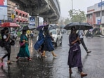 People in Kochi walk past covering themselves under an umbrella during rainfall. People in Kochi walk past covering themselves under an umbrella during rainfall.