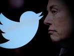Twitter logo and a photo of Elon Musk are displayed through magnifier in this illustration. 