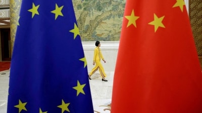 An attendant walks past EU and China flags in Beijing, China. (Reuters/File)