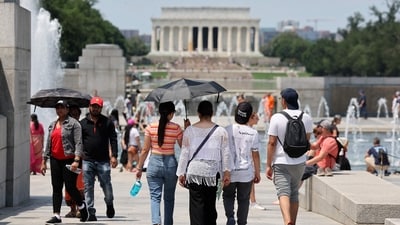 Visitors and tourists to the World War II Memorial shade themselves under umbrellas as temperatures reach into the 90's on July 03 in Washington, DC. (Getty Images via AFP) Visitors and tourists to the World War II Memorial shade themselves under umbrellas as temperatures reach into the 90's on July 03 in Washington, DC. (Getty Images via AFP)