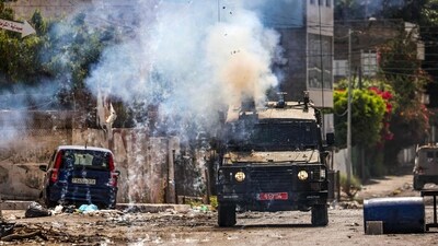 Israeli soldiers fire tear gas canisters from an armored vehicle during an ongoing military operation in the occupied West Bank city of Jenin on July 4. Jenin is a small city in the hilly, far north of the West Bank, near the border with Israel, and contains a teeming, concrete, and cinder-block refugee camp by the same name housing some 14,000 people. They are descendants of Palestinians dispossessed when Israel was created in 1948, and most are impoverished and unemployed. This harsh heritage generates die-hard hostility to Israel and support for Palestinian militant groups, reported Reuters. (Ronaldo Schemidt / AFP) Israeli soldiers fire tear gas canisters from an armored vehicle during an ongoing military operation in the occupied West Bank city of Jenin on July 4. Jenin is a small city in the hilly, far north of the West Bank, near the border with Israel, and contains a teeming, concrete, and cinder-block refugee camp by the same name housing some 14,000 people. They are descendants of Palestinians dispossessed when Israel was created in 1948, and most are impoverished and unemployed. This harsh heritage generates die-hard hostility to Israel and support for Palestinian militant groups, reported Reuters. (Ronaldo Schemidt / AFP)