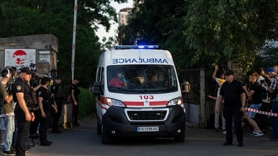 An ambulance leaves the Shevchenkivskyi courthouse past members of the media after an explosive device was detonated in the courthouse in Kyiv, Ukraine, Wednesday. (AP)