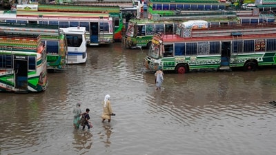 Pakistan Floods: Passengers wade through a flooded bus terminal caused by heavy monsoon rainfall in Lahore. (AP) Pakistan Floods: Passengers wade through a flooded bus terminal caused by heavy monsoon rainfall in Lahore. (AP)