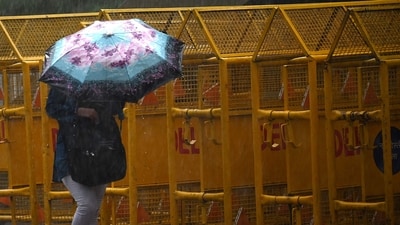 Weather updates: A woman shelters under an umbrella during a rainfall in New Delhi. (AFP) Weather updates: A woman shelters under an umbrella during a rainfall in New Delhi. (AFP)