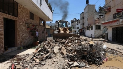 A bulldozer clears the rubble along a street in the occupied West Bank Jenin refugee camp on July 6, 2023, following a large-scale Israeli military operation that lasted for two days. (AFP) A bulldozer clears the rubble along a street in the occupied West Bank Jenin refugee camp on July 6, 2023, following a large-scale Israeli military operation that lasted for two days. (AFP)