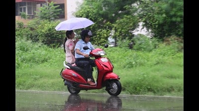 Commuters caught in the rain in Chandigarh on Friday. (Ravi Kumar/HT)