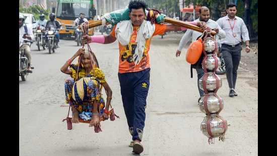 Dev and his grandmother reached the Raj Nagar Extension intersection of Delhi-Meerut Road on Friday morning and still have another 70km to cover before they reach their village Dharasu. (Sakib Ali/HT Photo)