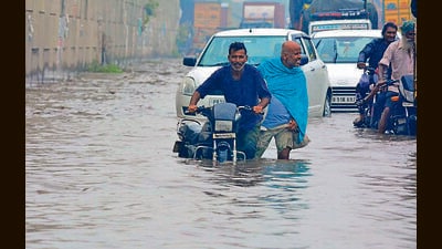 Commuters wade through the waterlogged GT Road in Ludhiana. (HT PHOTO) Commuters wade through the waterlogged GT Road in Ludhiana. (HT PHOTO)