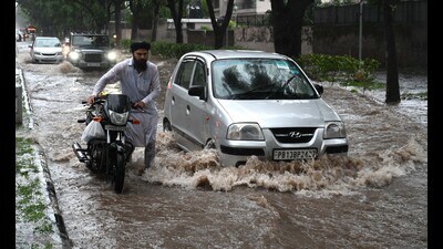 Commuters wading through a waterlogged Sector 36-37 dividing road in Chandigarh on Saturday.A total of 300.1 mm rain has been recorded in July so far. (Sanjeev Sharma/HT)