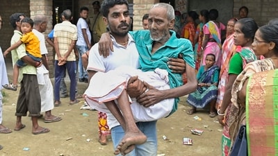 An elderly man is carried after he cast his vote for Panchayat elections at a polling station in Nadia district of West Bengal on Saturday. (PTI)