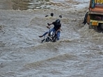 A man loses balance while riding a bike on a severely waterlogged Delhi-Gurugram Expressway A man loses balance while riding a bike on a severely waterlogged Delhi-Gurugram Expressway