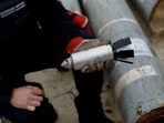 Ukrainian military serviceman holds a defused cluster bomb