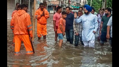 Patiala (Urban) AAP MLA Ajit Pal Singh Kohli wades through a waterlogged street during the inspection of rain-affected areas near Badi Nadi, in Patiala on Sunday. (ANI)