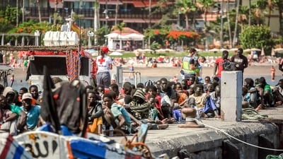 Migrants rest on the pier after disembarking from a 'cayuco' (wooden boat) following a rescue operation on July 4, (AFP) Migrants rest on the pier after disembarking from a 'cayuco' (wooden boat) following a rescue operation on July 4, (AFP)