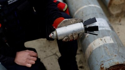 Ukrainian military serviceman holds a defused cluster bomb (REUTERS)