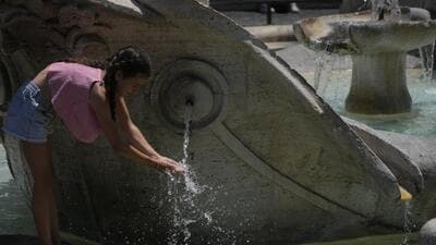 A child refreshes at the Barcaccia fountain of Rome's Spanish Steps, on Monday. An intense heatwave has reached Italy, bringing temperatures close to 40°C in many cities across the country. (AP)