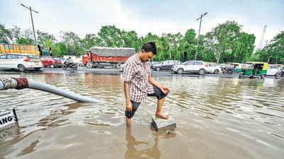 A civic worker attempts to open choked drains on a waterlogged road at Pragati Maidan Ring Road in New Delhi on Monday. (Raj K Raj/HT Photo) A civic worker attempts to open choked drains on a waterlogged road at Pragati Maidan Ring Road in New Delhi on Monday. (Raj K Raj/HT Photo)