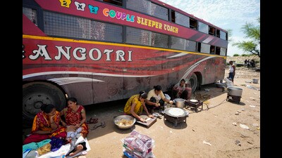 Pilgrims headed to the Himalayan shrine of Amarnath prepare food in the shade of a parked bus outside a base camp in Jammu. (AP Photo) Pilgrims headed to the Himalayan shrine of Amarnath prepare food in the shade of a parked bus outside a base camp in Jammu. (AP Photo)