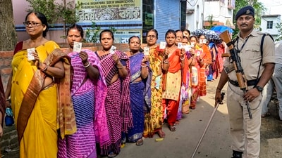 A CISF paramilitary jawan guards as people wait to cast their votes at a polling booth during panchayat repolls in Nadia district of West Bengal. (PTI)