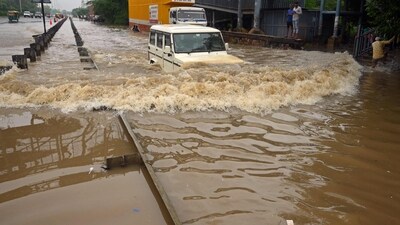 A commuter drives his car along a flooded highway after heavy monsoon rains in Gurugram. (AFP) A commuter drives his car along a flooded highway after heavy monsoon rains in Gurugram. (AFP)