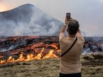 A man takes pictures as lava emerges from a fissure of the Fagradalsfjall volcano near the Litli-Hrútur mountain, some 30 kilometers (19 miles) southwest of Reykjavik, Iceland, Monday July 10, 2023. Authorities in Iceland on Tuesday warned spectators to stay away from a newly erupting volcano that is spewing lava and noxious gases from a fissure in the country’s southwest 